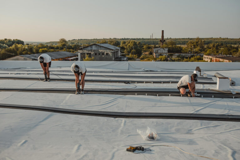 commercial roof repair-crew of roofers repairing commercial flat roofing materials
