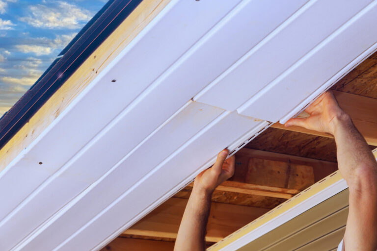 fascia board repair-close up of man repairing fascia and soffit