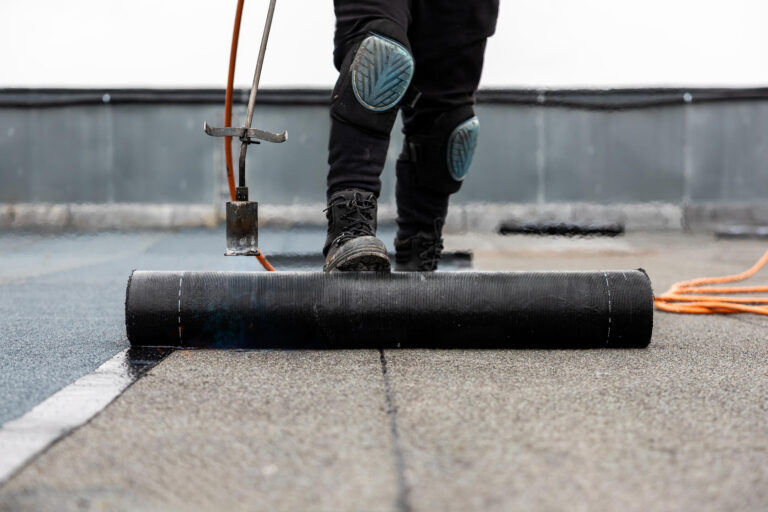 rubber roofing-close up of roofer installing rubber roofing on flat roof