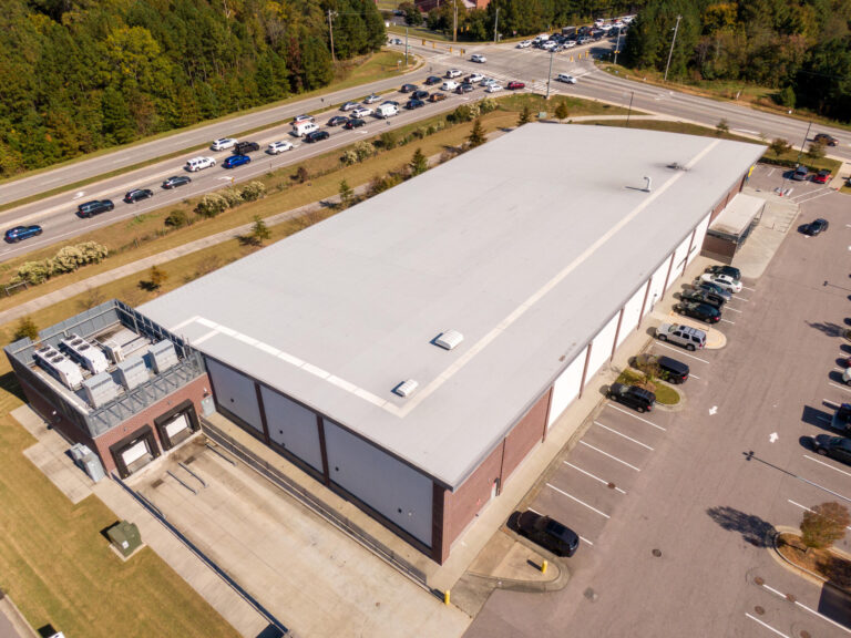 tpo roof warranty-aerial view of commercial brick building with tpo flat roofing