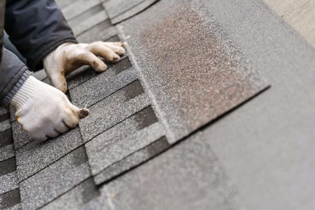 roofer installing new shingles on roof