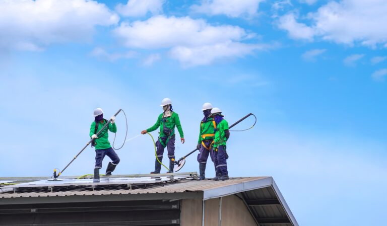 group of cleaners scrubbing commercial roof with large brush