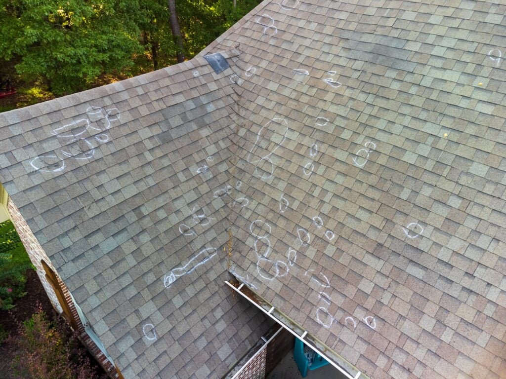 marking storm damage at asphalt roof