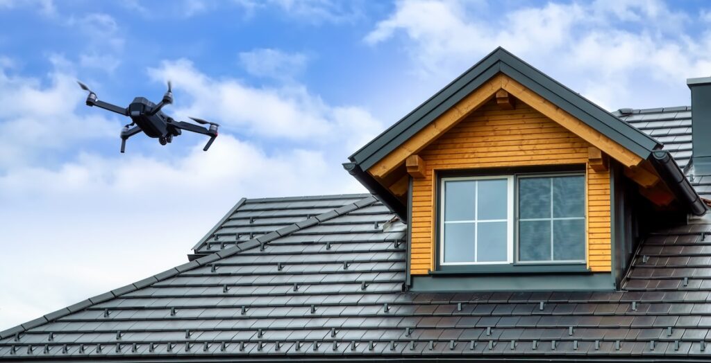 Drone in the air inspecting the roof over the house