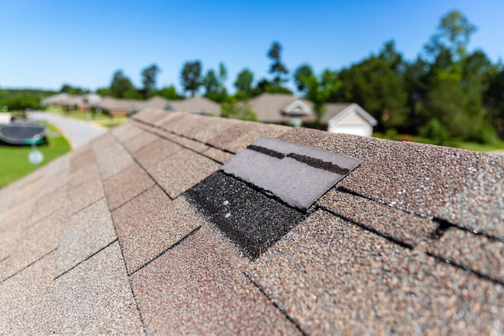 Missing shingles on roof due to storm damage.