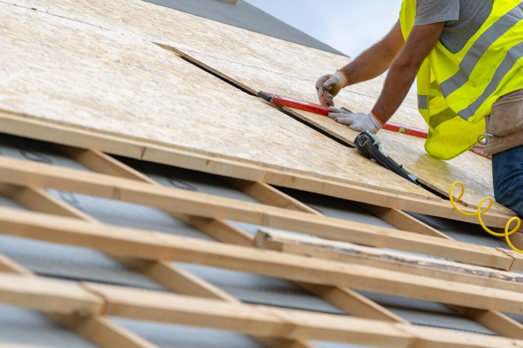 Building construction process of new wooden roof on wood frame house