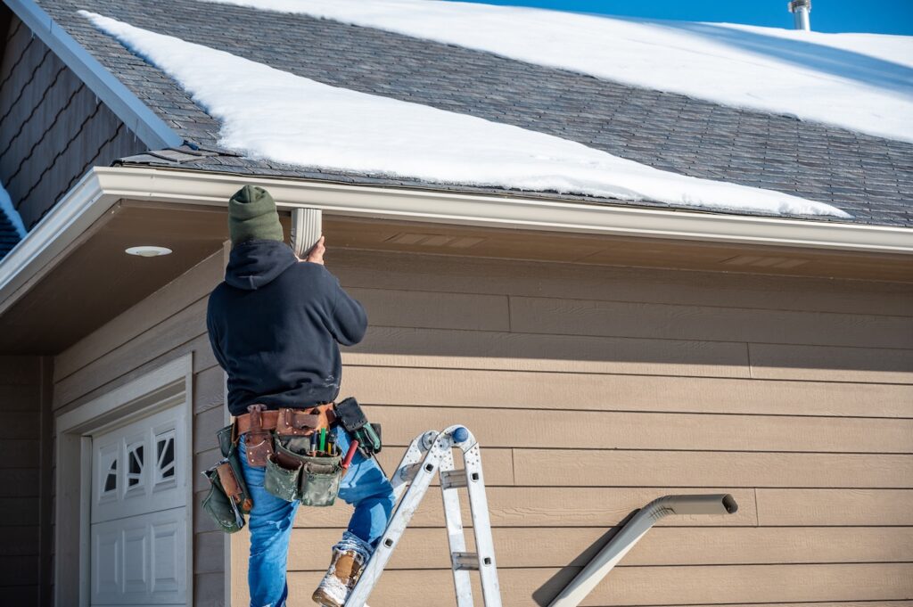 roofer checking snowy roof