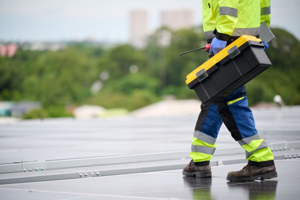 guy holding toolbox on top of commercial roof